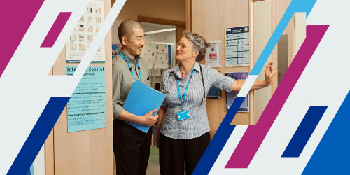 Two doctors standing by the door and discussing with a file in hand.